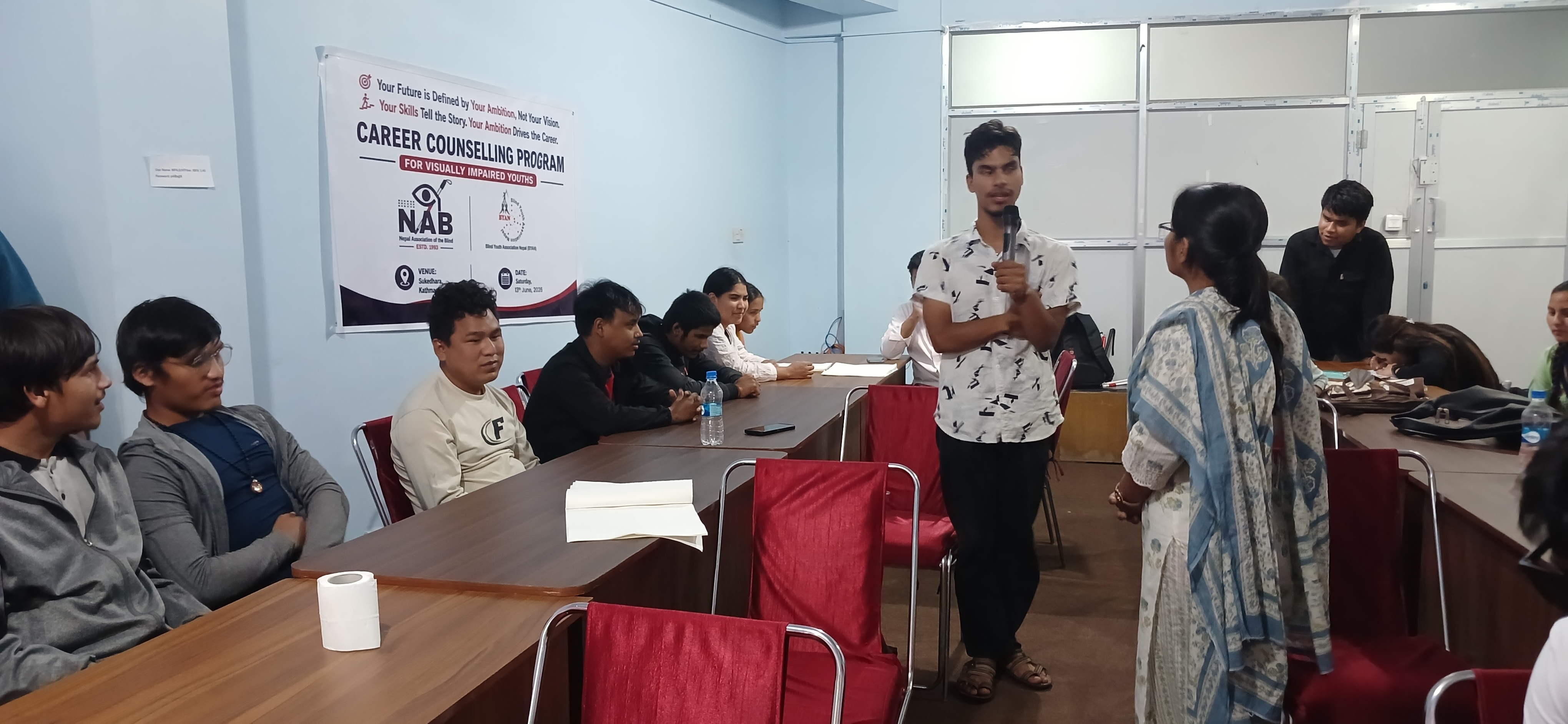 A participant speaking into a microphone at a counselling session